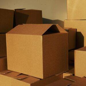 Stacked cardboard boxes ready for shipping or storage in a warehouse setting.